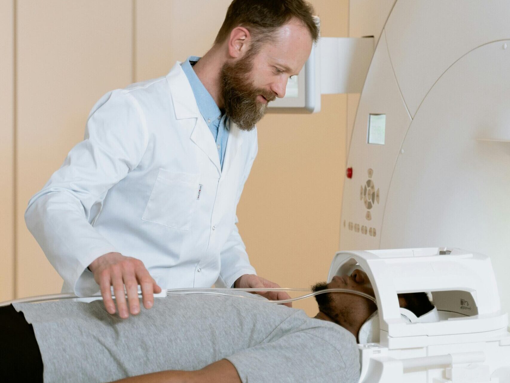 Doctor helping patient during MRI scan in a modern medical facility.